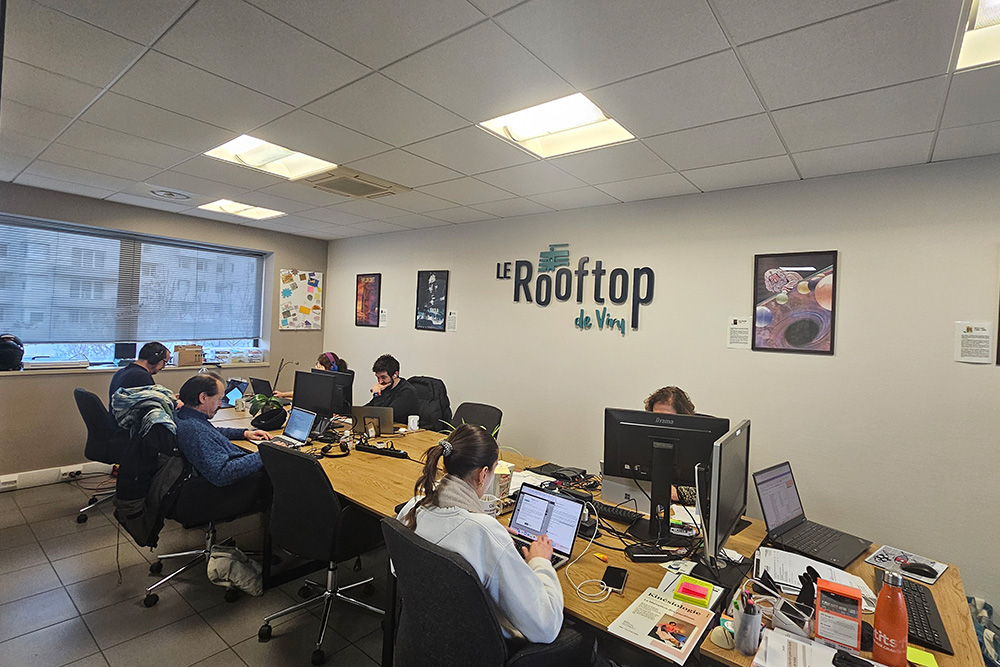 alt="Open space coworking avec vue sur rooftop"